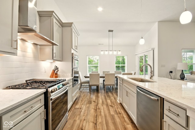 19257 Red Willow Ln, Noblesville, IN 46062 - kitchen with stainless steel appliances, wall chimney range hood, a sink, light wood-style floors, and healthy amount of natural light