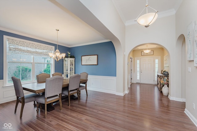 6337 Ederline Ln, Noblesville, IN 46062 - dining space featuring arched walkways, a chandelier, wood finished floors, ornamental molding, and a wainscoted wall