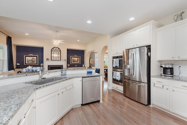 6337 Ederline Ln, Noblesville, IN 46062 - kitchen featuring stainless steel appliances, a sink, arched walkways, ceiling fan, and plenty of natural light
