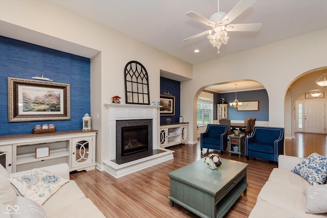 6337 Ederline Ln, Noblesville, IN 46062 - living room with arched walkways, wood finished floors, a ceiling fan, a fireplace, and baseboards