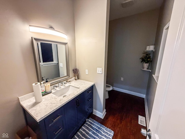 201 N Tacoma Ave, Indianapolis, IN 46201 - bathroom with vanity, wood finished floors, toilet, and baseboards