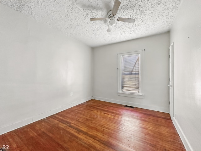 145 S 7th Ave, Beech Grove, IN 46107 - empty room with ceiling fan, a textured ceiling, wood finished floors, and baseboards