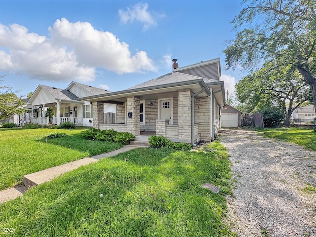 145 S 7th Ave, Beech Grove, IN 46107 - view of front of property with a porch, stone siding, a front yard, and an outbuilding
