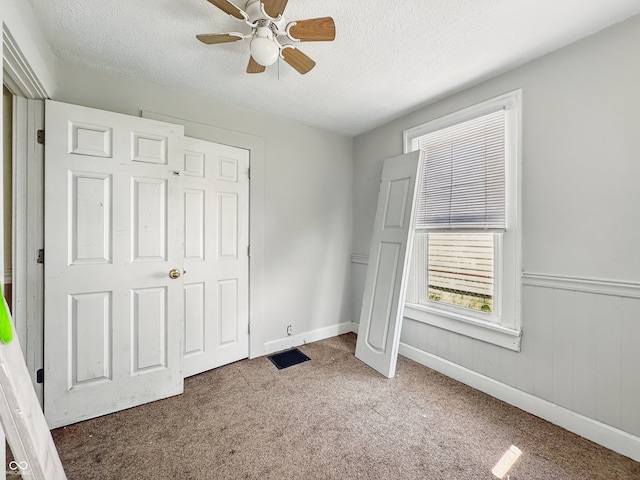 145 S 7th Ave, Beech Grove, IN 46107 - unfurnished bedroom featuring a textured ceiling, carpet, ceiling fan, and baseboards