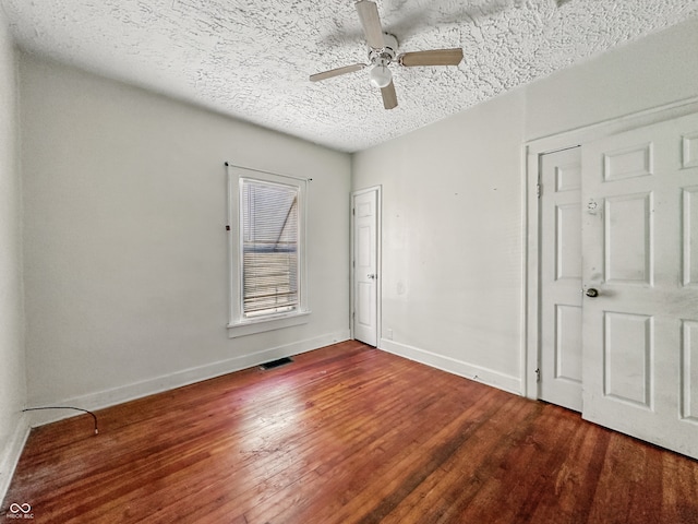 145 S 7th Ave, Beech Grove, IN 46107 - unfurnished bedroom featuring wood finished floors, a textured ceiling, baseboards, and a ceiling fan