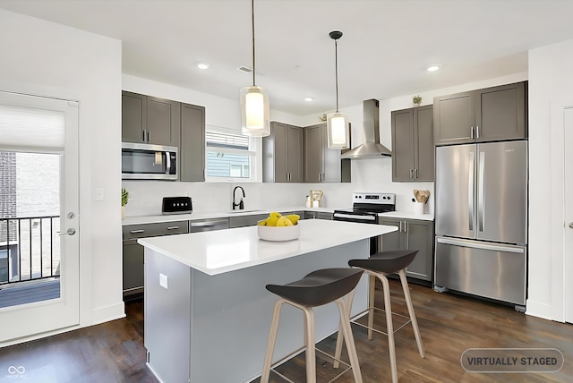 727 N Illinois St Unit 202, Indianapolis, IN 46204 - kitchen with stainless steel appliances, wall chimney exhaust hood, a kitchen island, dark wood-type flooring, and light countertops