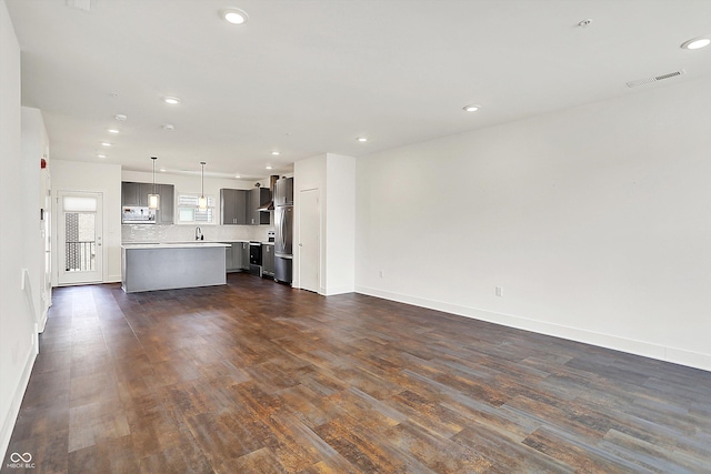 727 N Illinois St Unit 202, Indianapolis, IN 46204 - unfurnished living room featuring dark wood-style flooring, a sink, baseboards, and recessed lighting