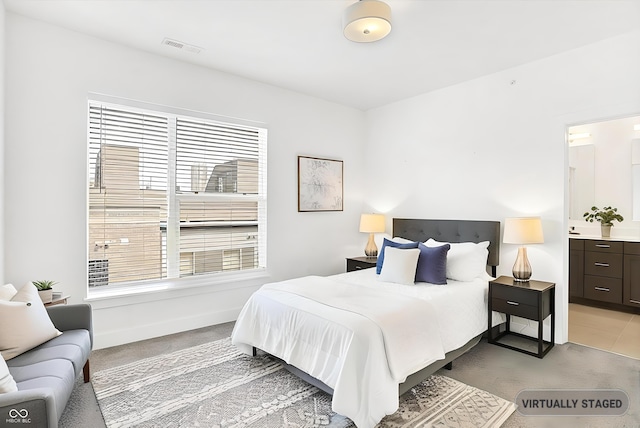 727 N Illinois St Unit 202, Indianapolis, IN 46204 - bedroom featuring light carpet, ensuite bathroom, and baseboards