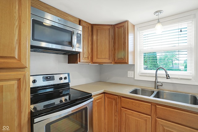 6838 Five Points Rd, Indianapolis, IN 46259 - kitchen with appliances with stainless steel finishes, a sink, light countertops, brown cabinetry, and decorative light fixtures