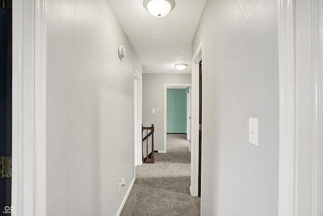 6838 Five Points Rd, Indianapolis, IN 46259 - hall with a textured ceiling, carpet floors, baseboards, and an upstairs landing