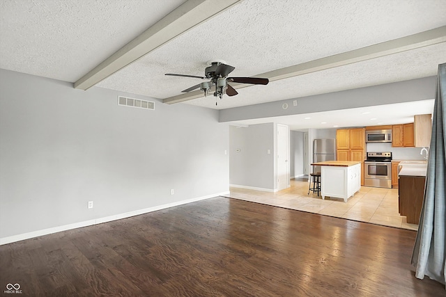 6838 Five Points Rd, Indianapolis, IN 46259 - unfurnished living room featuring ceiling fan, light wood finished floors, baseboards, beam ceiling, and a sink
