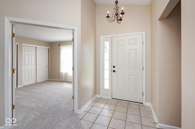 6105 Franklin Villas Way, Indianapolis, IN 46237 - foyer entrance with a chandelier, baseboards, light tile patterned floors, and light carpet