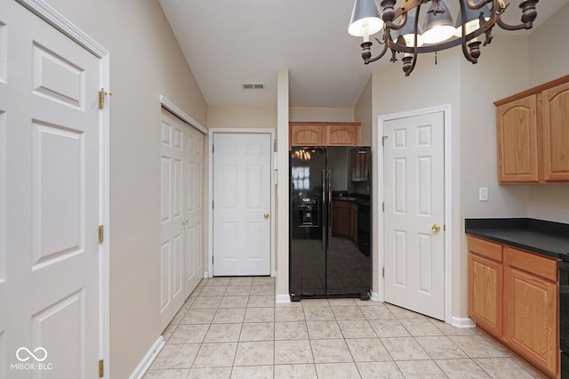 6105 Franklin Villas Way, Indianapolis, IN 46237 - kitchen featuring black fridge with ice dispenser, dark countertops, lofted ceiling, a chandelier, and baseboards