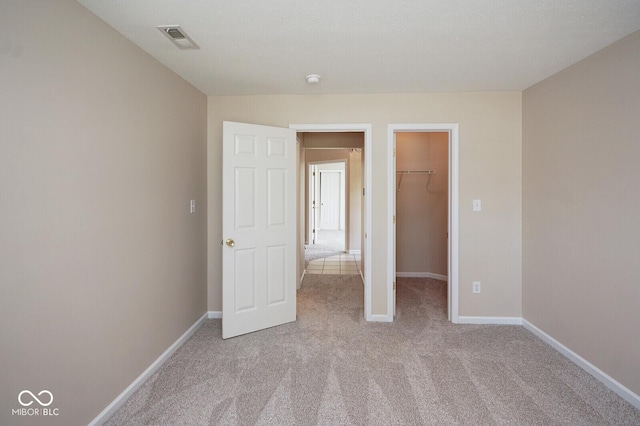 6105 Franklin Villas Way, Indianapolis, IN 46237 - unfurnished bedroom with a walk in closet, carpet flooring, baseboards, and a closet