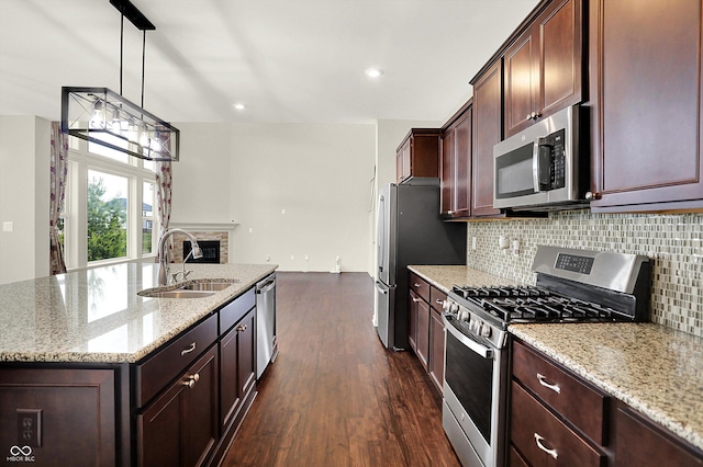 7046 Allegiance Ct, Indianapolis, IN 46259 - kitchen with stainless steel appliances, a sink, backsplash, dark wood-style floors, and a kitchen island with sink