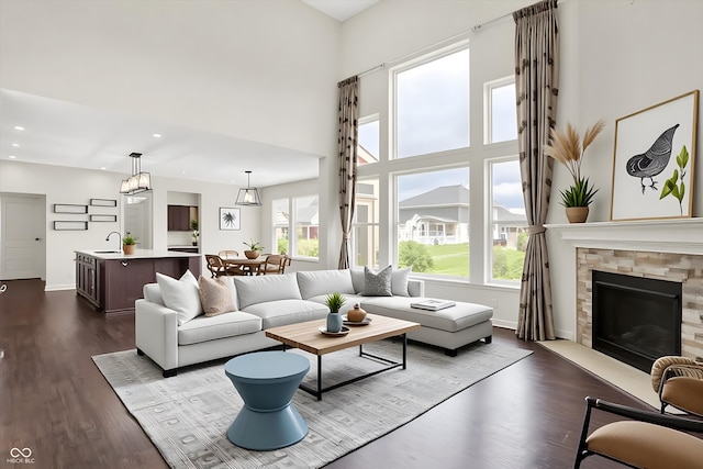7046 Allegiance Ct, Indianapolis, IN 46259 - living room with dark wood-style flooring, baseboards, a fireplace, a high ceiling, and recessed lighting