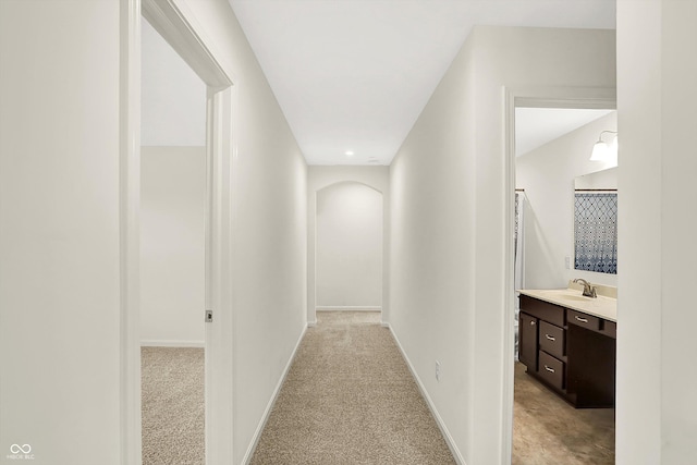 7046 Allegiance Ct, Indianapolis, IN 46259 - hall featuring a sink, light colored carpet, and baseboards