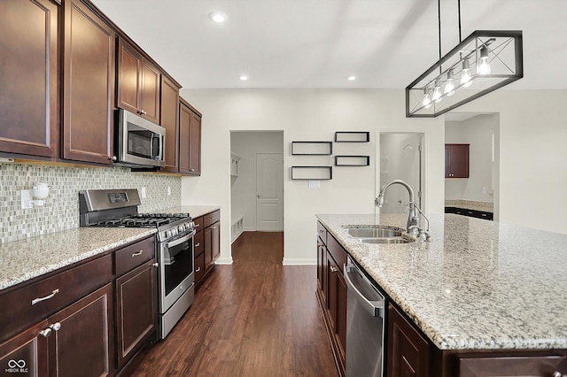 7046 Allegiance Ct, Indianapolis, IN 46259 - kitchen featuring appliances with stainless steel finishes, a sink, dark wood-type flooring, tasteful backsplash, and light stone counters