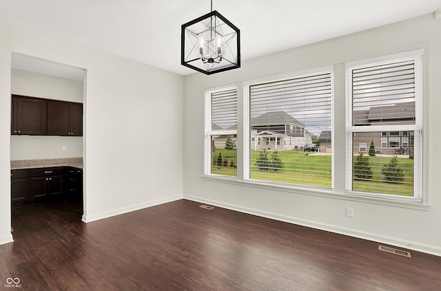 7046 Allegiance Ct, Indianapolis, IN 46259 - unfurnished dining area with dark wood-type flooring, a chandelier, and baseboards