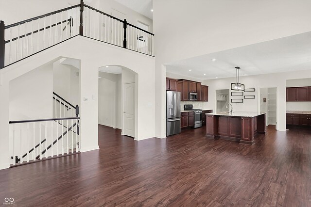 7046 Allegiance Ct, Indianapolis, IN 46259 - kitchen featuring appliances with stainless steel finishes, light countertops, arched walkways, dark wood-style flooring, and recessed lighting