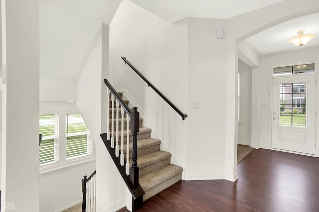 7046 Allegiance Ct, Indianapolis, IN 46259 - entryway featuring arched walkways, dark wood-style flooring, baseboards, and stairway