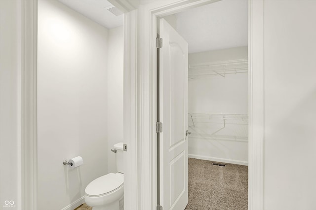 7046 Allegiance Ct, Indianapolis, IN 46259 - bathroom with toilet, a walk in closet, and baseboards
