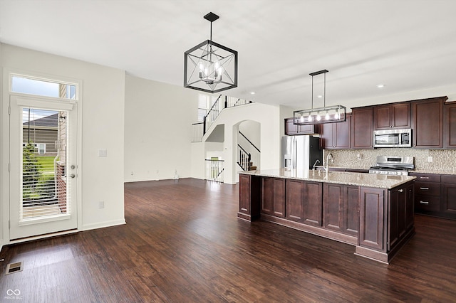 7046 Allegiance Ct, Indianapolis, IN 46259 - kitchen featuring stainless steel appliances, dark wood-type flooring, dark brown cabinets, tasteful backsplash, and a center island with sink