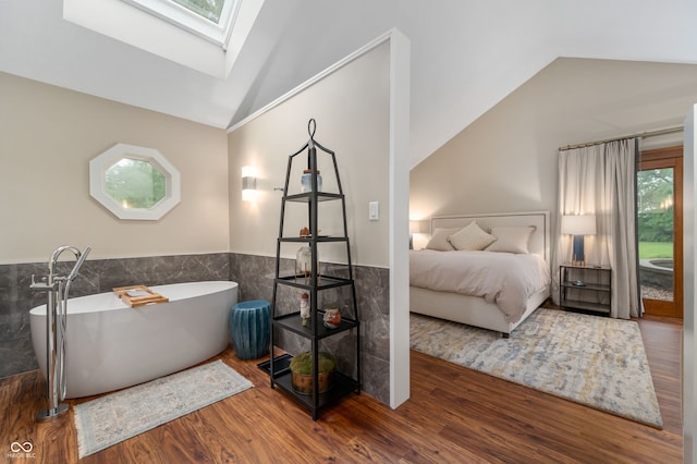 2411 N County Road 500 W, Muncie, IN 47304 - full bath with vaulted ceiling, a skylight, tile walls, a freestanding tub, and wood finished floors