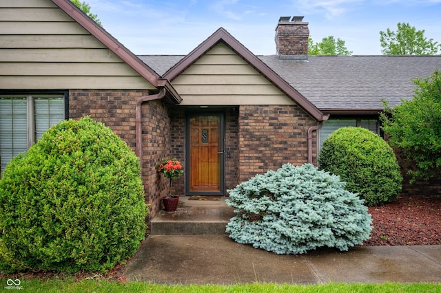 2411 N County Road 500 W, Muncie, IN 47304 - view of exterior entry with a chimney, a shingled roof, and brick siding