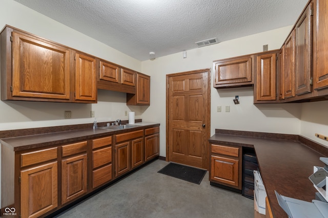 2411 N County Road 500 W, Muncie, IN 47304 - kitchen featuring a sink, dark countertops, a textured ceiling, and brown cabinets