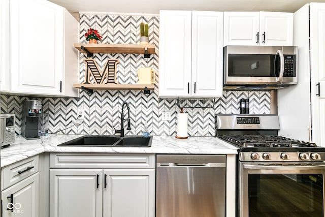 635 E 10th St, Indianapolis, IN 46202 - kitchen with stainless steel appliances, a sink, decorative backsplash, white cabinets, and light stone countertops