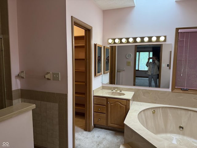 6609 N Tuxedo Ln, Indianapolis, IN 46220 - bathroom with vanity, a jetted tub, and a walk in closet