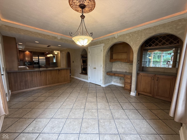 6609 N Tuxedo Ln, Indianapolis, IN 46220 - unfurnished living room featuring ornamental molding, a textured ceiling, light tile patterned flooring, arched walkways, and baseboards