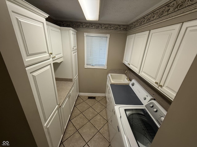 6609 N Tuxedo Ln, Indianapolis, IN 46220 - washroom featuring baseboards, washing machine and clothes dryer, cabinet space, light tile patterned floors, and ornamental molding