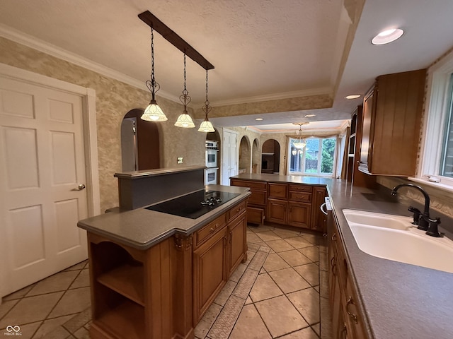 6609 N Tuxedo Ln, Indianapolis, IN 46220 - kitchen with arched walkways, a sink, black electric stovetop, brown cabinetry, and double oven