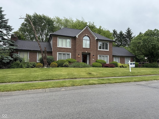 6609 N Tuxedo Ln, Indianapolis, IN 46220 - colonial house featuring brick siding and a front lawn