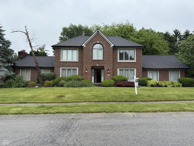 6609 N Tuxedo Ln, Indianapolis, IN 46220 - view of front of property with brick siding, a front yard, a chimney, and a shingled roof