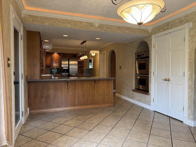 6609 N Tuxedo Ln, Indianapolis, IN 46220 - kitchen with stainless steel appliances, arched walkways, crown molding, a peninsula, and light tile patterned flooring