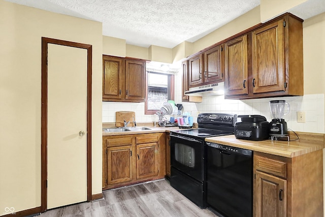 926 Brookside Ln, Plainfield, IN 46168 - kitchen with black appliances, a sink, light wood-type flooring, light countertops, and under cabinet range hood