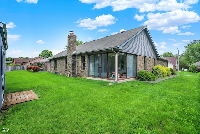 926 Brookside Ln, Plainfield, IN 46168 - rear view of house featuring brick siding, a sunroom, a chimney, and roof with shingles