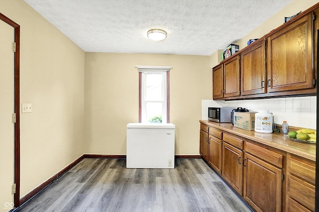 926 Brookside Ln, Plainfield, IN 46168 - washroom featuring light wood-style flooring, a textured ceiling, baseboards, and cabinet space