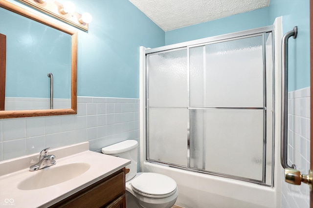 926 Brookside Ln, Plainfield, IN 46168 - bathroom featuring tile walls, vanity, toilet, enclosed tub / shower combo, and wainscoting