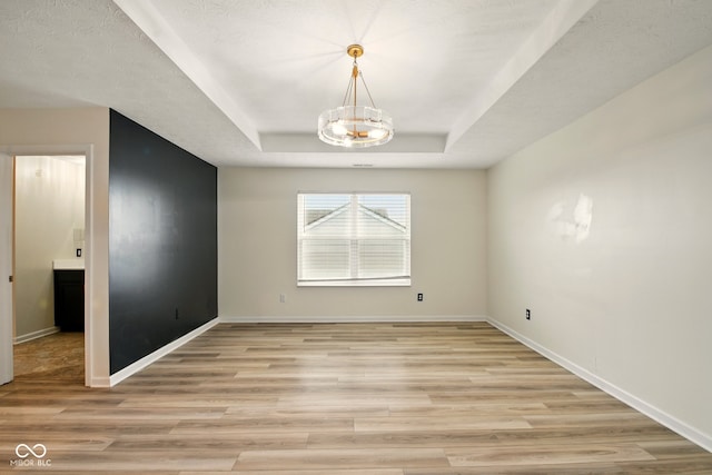 1454 Silver Pine Ln, Sheridan, IN 46069 - unfurnished room featuring light wood-style flooring, a tray ceiling, baseboards, and a chandelier