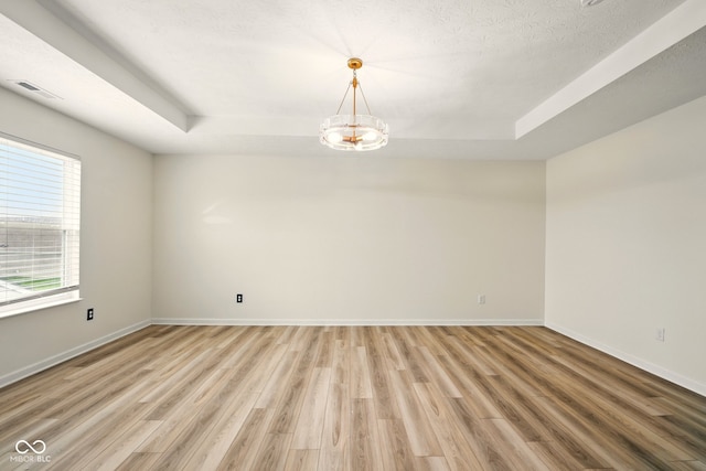 1454 Silver Pine Ln, Sheridan, IN 46069 - unfurnished room with a raised ceiling, light wood-style flooring, a chandelier, and baseboards