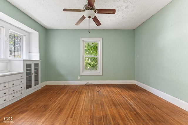 3134 N College Ave, Indianapolis, IN 46205 - empty room featuring wood finished floors, a textured ceiling, a ceiling fan, and baseboards