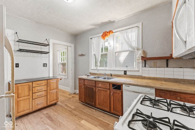 3134 N College Ave, Indianapolis, IN 46205 - kitchen with white appliances, a textured wall, light wood-type flooring, a sink, and a textured ceiling
