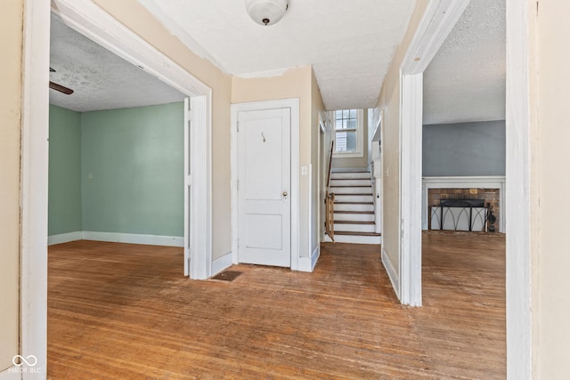 3134 N College Ave, Indianapolis, IN 46205 - entrance foyer with a textured ceiling, a fireplace, baseboards, stairs, and wood finished floors