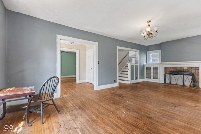 3134 N College Ave, Indianapolis, IN 46205 - dining space with wood finished floors, stairway, a chandelier, baseboards, and a tile fireplace