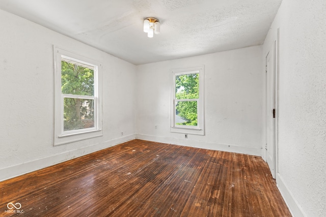3134 N College Ave, Indianapolis, IN 46205 - empty room featuring hardwood / wood-style floors, healthy amount of natural light, baseboards, and a textured ceiling