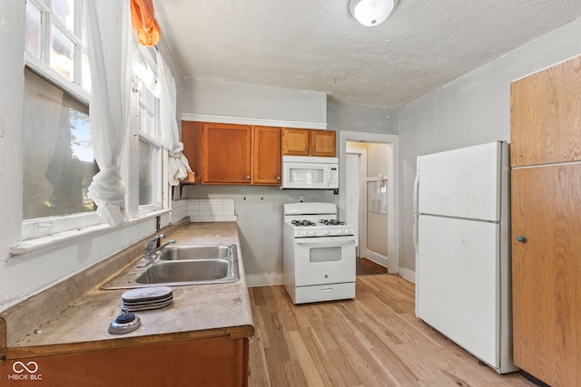 3134 N College Ave, Indianapolis, IN 46205 - kitchen with white appliances, a sink, brown cabinets, light wood-type flooring, and light countertops